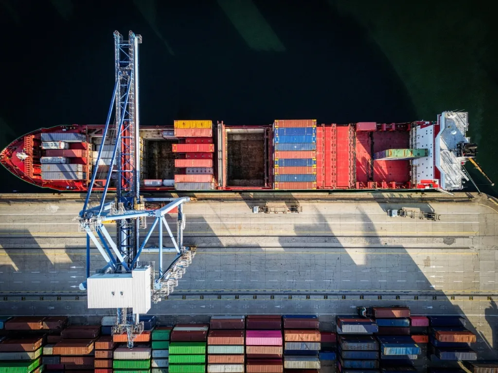 Picture of a vessel in port loading containers.